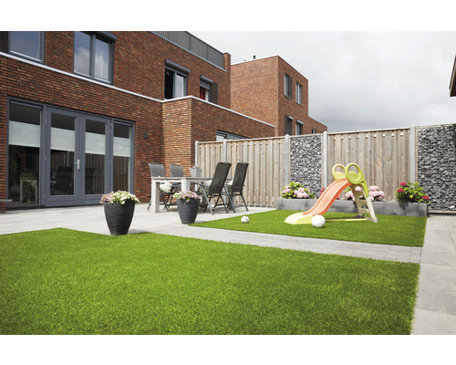 Jardin avec gazon synthétique, aire de jeux et coin salon