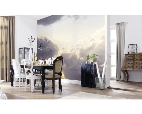 Salle à manger avec papier peint nuages, table à manger et meubles pour une ambiance lumineuse.