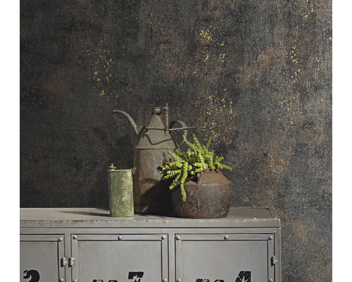 Nature morte décorative avec plante, cruche et bidon sur une armoire devant un mur à motifs