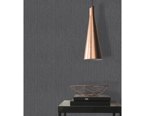 Papier peint gris avec texture textile, table avec décoration et lampe