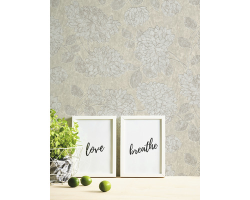 Papier peint à motif floral, deux cadres avec les inscriptions Amour et Respiration, plante en pot et citrons verts sur une table
