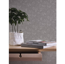 Image d''une pièce avec un papier peint à motifs, une table avec une plante et des livres