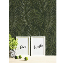Papier peint avec motif de palmiers tropicaux, combiné à des éléments décoratifs tels que des cadres photo et une plante en pot