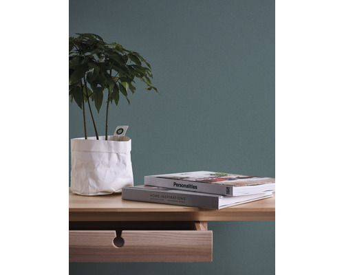 Nature morte décorative avec plante dans un sac en papier, livres et table à tiroirs