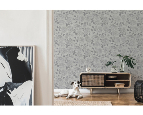 Salon avec papier peint à motifs floraux, commode et chien