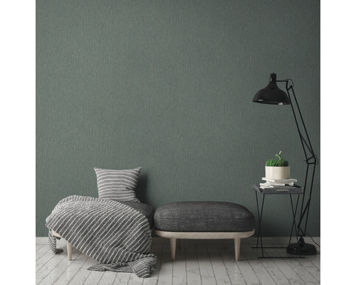 Salon avec papier peint textile gris, fauteuil, tabouret et lampadaire