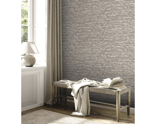 Intérieur avec papier peint aspect pierre, banc, livre et décoration