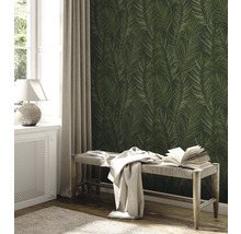 Une pièce avec un papier peint à motifs de feuilles de palmier, une fenêtre, un radiateur et un banc.