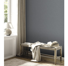Salon avec mur gris, banc, livre et jeté de lit