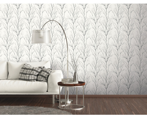 Wohnzimmer mit weissem Sofa und einer Wand mit Tapete mit Astmuster