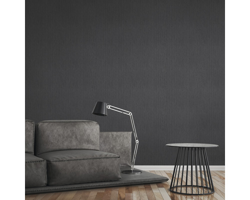 Salon avec canapé, lampadaire et table d''appoint devant un mur sombre