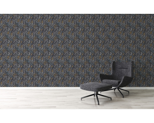 Salon avec papier peint à motifs et fauteuil avec repose-pieds