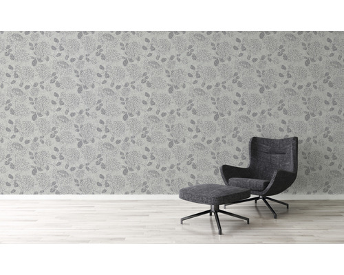 Vue d''une pièce avec du papier peint à motifs floraux et un fauteuil avec repose-pieds