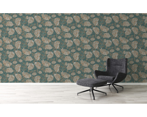 Wand mit floral gemusterter Tapete und Sessel mit Fußhocker
