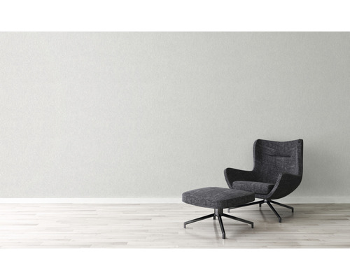 Moderner Sessel mit Fußhocker vor einer Wand