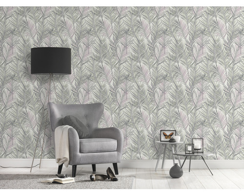 Pièce décorée avec fauteuil, lampadaire et papier peint à motifs de feuilles