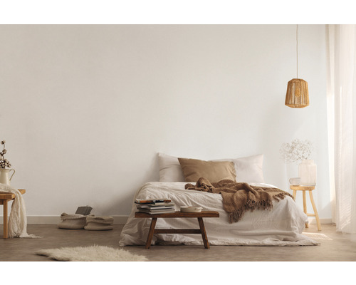 Chambre claire avec lit, tabouret en bois et lampe tricotée