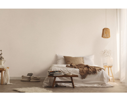 Espace chambre lumineux avec lit, tabouret en bois, lampe et éléments décoratifs pour une ambiance conviviale