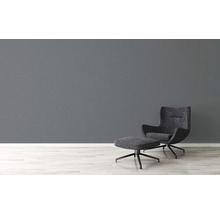 Salon moderne avec fauteuil et repose-pieds sur un sol en bois clair