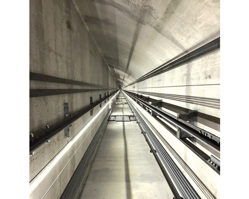 Ein Tunnel mit Betonwänden und Metallschienen.