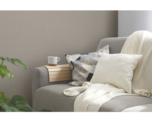 Graues Sofa mit Kissen, Decke und einer Tasse auf einem Holztablett