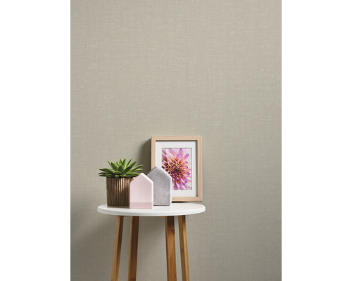 Beige Textiltapete im Interieur mit Tisch, Pflanze und Bild
