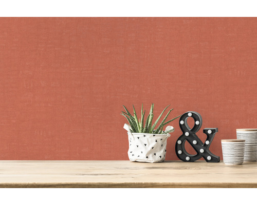 Gros plan d''un mur avec du papier peint textile, une plante d''intérieur, des lettres décoratives et des gobelets en céramique sur une table