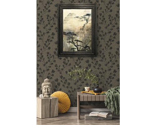 Intérieur décoratif avec papier peint à motifs, image encadrée et statue de Bouddha.