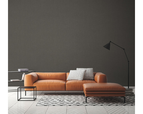 Salon moderne avec canapé marron, tapis à motif géométrique et lampadaire.