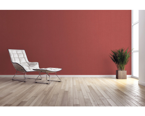 Salon avec fauteuil, repose-pieds, plante d''intérieur et décoration murale