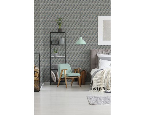 Chambre avec lit, fauteuil, étagère et papier peint à motif géométrique