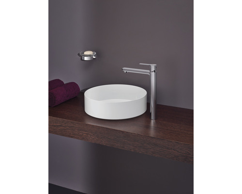 Lavabo de salle de bain avec robinet, porte-savon et serviettes sur une étagère en bois.