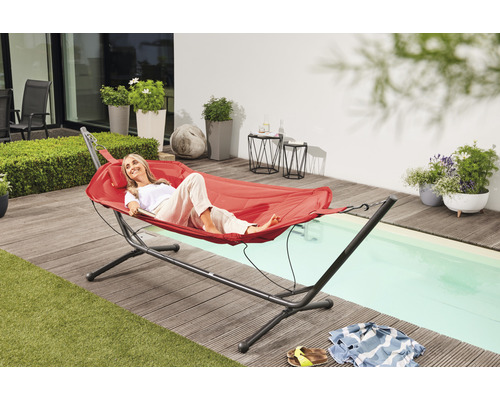 Szene im Freien mit Frau, die in einer roten Hängematte auf einer Terrasse entspannt