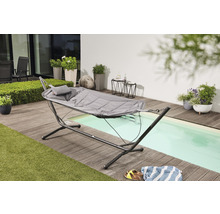Scène de jardin avec hamac et cadre en acier sur une terrasse en bois à côté d''une piscine