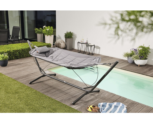 Gartenszene mit Hängematte und Stahlrahmen auf einer Holzterrasse neben einem Pool