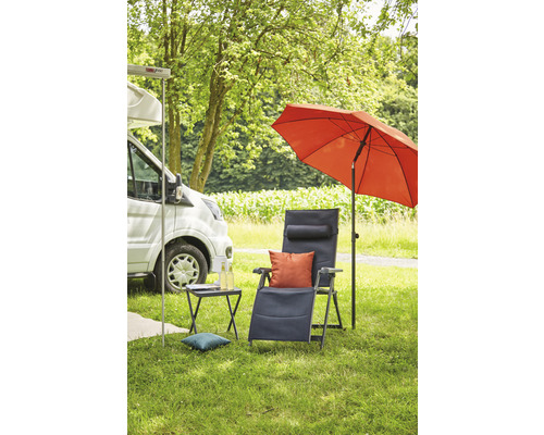 Scène de camping avec camping-car, parasol, chaise longue et table d''appoint sur une pelouse