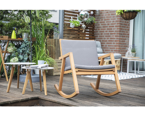 Scène avec un fauteuil à bascule en bois avec des coussins gris et deux tables d''appoint rondes sur une terrasse.