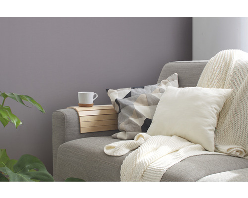 Graues Sofa mit Kissen, Überwurf und Ablage mit Tasse
