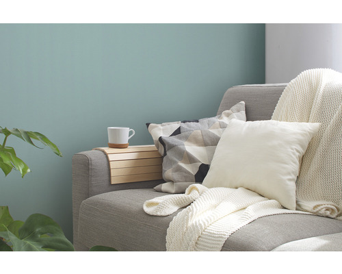Salon décoratif avec canapé, coussins, jeté, tablette en bois et tasse