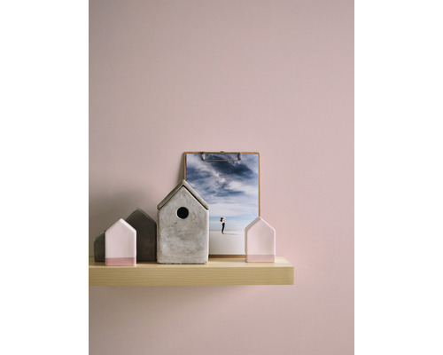 Maisons décoratives en béton et un porte-photos avec une photographie sur une étagère en bois.