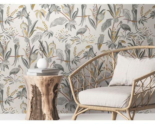 Scène avec un ensemble de fauteuils en rotin devant un papier peint à motifs d''oiseaux