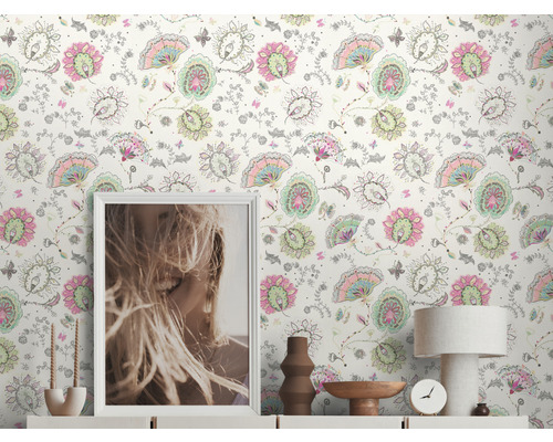 Intérieur avec papier peint à fleurs, commode, lampe de table, horloge et décoration