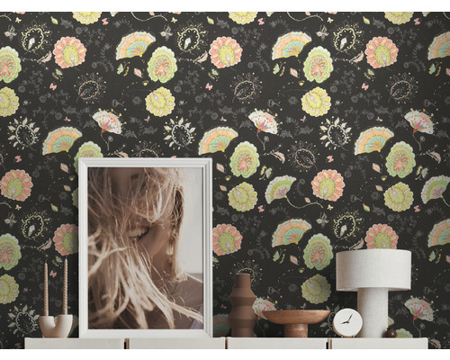 Vue d''une pièce avec papier peint à motifs, photo, lampe et objets de décoration sur un buffet