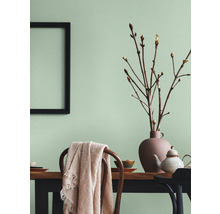 Salle à manger lumineuse avec table en bois, chaises, décorations et un cadre photo au mur