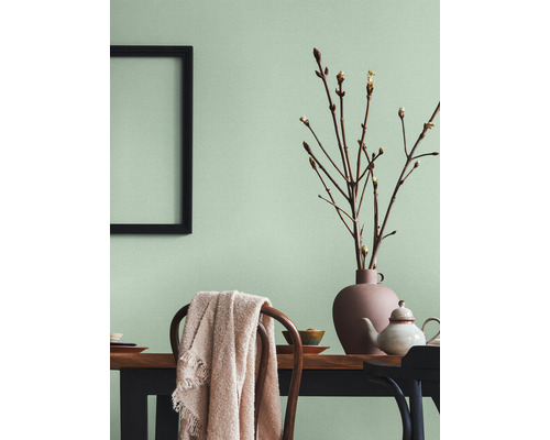 Salle à manger lumineuse avec table en bois, chaises, décorations et un cadre photo au mur