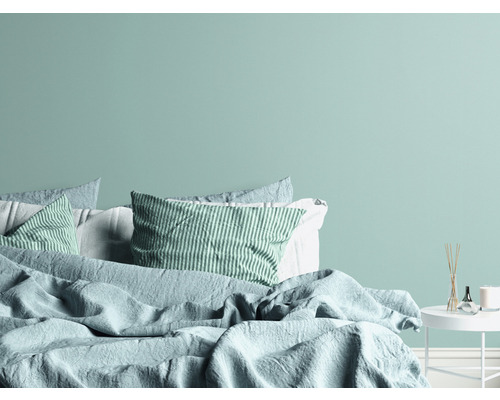 Chambre avec lit, coussins et table de chevet