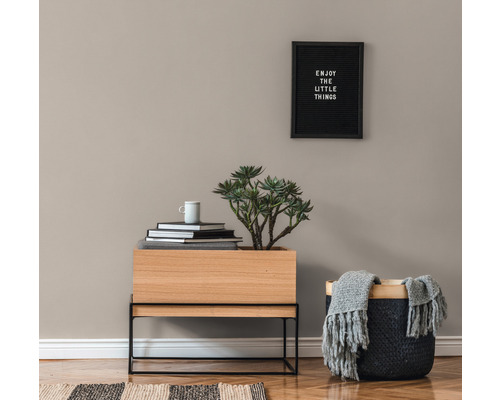 Intérieur décoratif avec jardinière en bois, panier, livres et tableau mural.