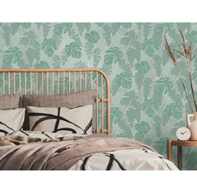 Chambre avec lit et papier peint à feuilles tropicales