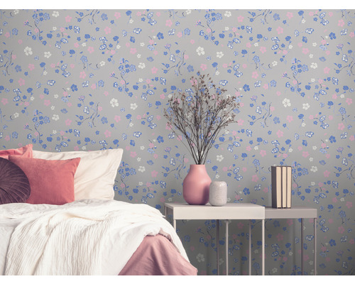 Chambre avec papier peint à motifs floraux, lit et table de chevet