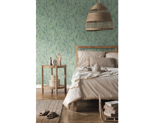 Chambre lumineuse avec papier peint à motifs, lit, table de chevet et lampe tissée